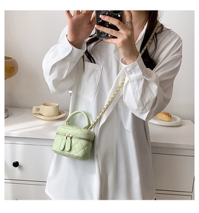Detail of light green quilted PU crossbody bag showing dual zippers and chain strap