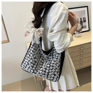 Detail of floral lace tote bag featuring an elegant embroidered bow on the side