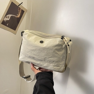 Minimalist beige nylon crossbody bag with multi-layer zippers and woven strap for women