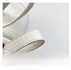 Close-up of white PU leather handbag featuring embossed crocodile animal skin texture