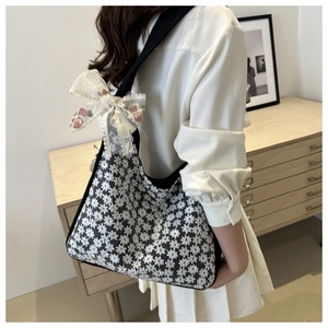 Detailed close-up of a floral lace hobo bag featuring a large decorative white mesh bow