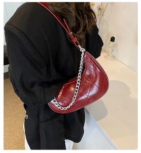 Détail du sac bandoulière en similicuir matelassé bordeaux avec chaîne argentée