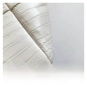 Close-up of white PU leather bag with crocodile embossed texture and fine stitching
