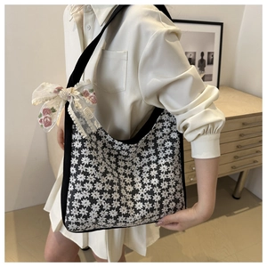 Detailed close-up of 3D lace embroidery and floral bow on the canvas handbag
