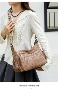 Close-up of vintage brown PU leather bag featuring unique geometric stitching and wide strap