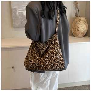 Rear view of a model wearing the large leopard print canvas tote bag in a minimalist room