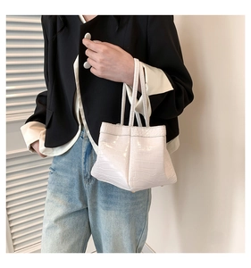 Close-up of minimalist cream PU leather handbag with elegant crocodile texture