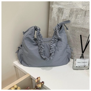 Grayish blue nylon crossbody bag with pleated strap and drawstring side pocket detail
