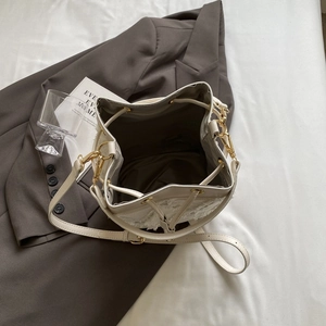 Top view of white tweed bucket bag interior with brown lining and gold hardware details