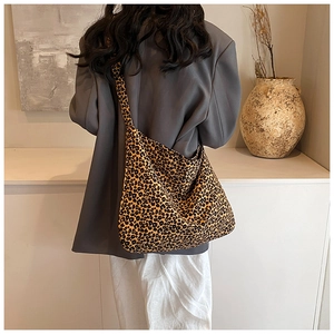 Detail view of large leopard print canvas crossbody bag with wide shoulder strap