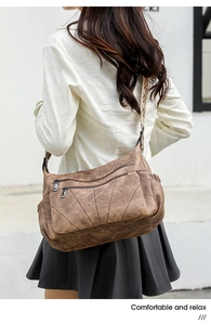 Detail of vintage brown PU leather crossbody bag with ethnic woven strap and multiple zippers