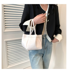 Detailed view of white crocodile pattern PU leather handbag with dual handles and structured base