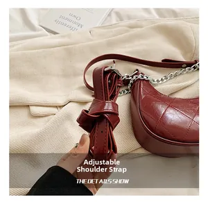 Vue détaillée de la bandoulière réglable en cuir sur un sac bandoulière matelassé bordeaux