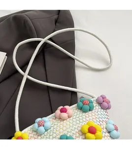 Detail of soft cotton linen crossbody bag with colorful fabric flowers and rope strap