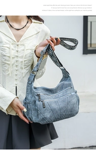 Close-up of blue PU leather hobo bag featuring multi-zipper pockets and ethnic woven strap