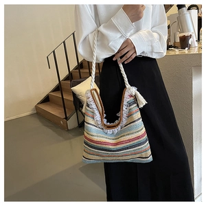 Detail of colorful woven tote bag featuring white lace trim and fringe cotton handles