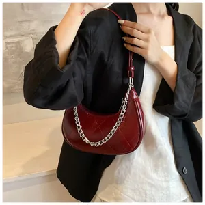 Détail du sac demi-lune en cuir PU rouge matelassé avec chaîne en métal argenté tendance