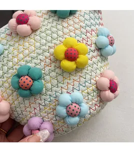 Close-up of woven linen crossbody bag with colorful 3D fabric flowers and zigzag stitching