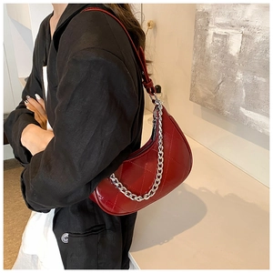 Détail du sac demi-lune rouge matelassé avec chaîne argentée et bandoulière réglable
