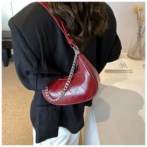 Détail du sac croissant bordeaux avec matelassage losange et chaîne argentée