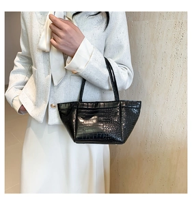 Detailed macro view of black crocodile pattern PU leather handbag with sleek metal buckle