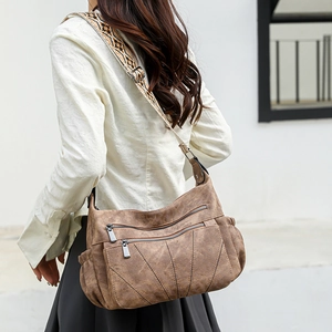 Detail of brown PU leather crossbody bag featuring multi-pocket design and ethnic wide strap