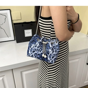 Detail of blue leopard print bucket bag with silver chain and large pearl accents