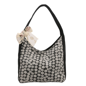 Black canvas tote bag with white floral lace embroidery and a decorative bow charm