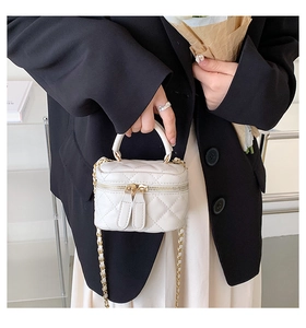 Detail of white quilted PU leather mini bag with gold chain and dual zipper closure