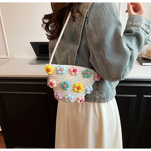Detail of hand-woven crossbody bag with colorful 3D plush flowers and rope shoulder strap
