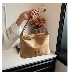 Close-up of geometric patchwork PU leather bag with square buckle in camel brown color