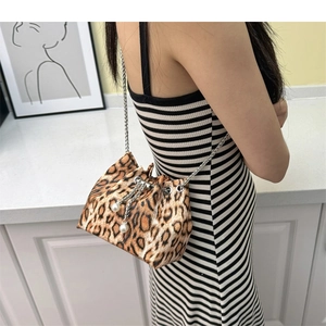 Detail of leopard print bucket bag featuring silver chain strap and pearl drawstring closure