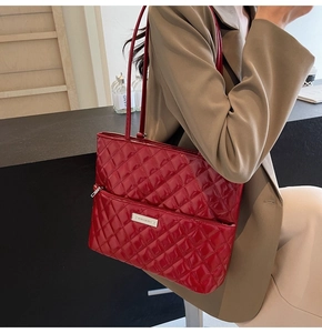 Detailed close-up of a red quilted patent leather shoulder bag with silver logo plaque