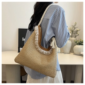 Detail of hand-woven straw shoulder bag featuring white lace trim and thick cotton rope strap