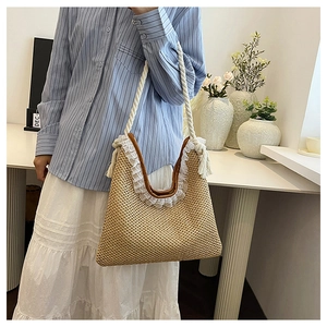 Detailed shot of straw woven shoulder bag with delicate white lace trim and cotton straps