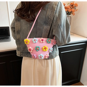 Detail of pink woven crossbody bag with colorful handmade 3D floral decorations
