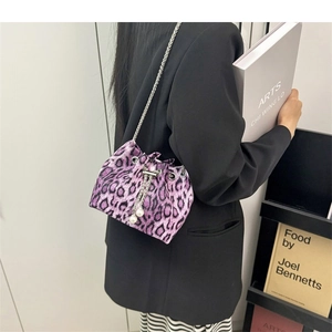 Detail of purple leopard print bucket bag with metal chain strap and pearl drawstring