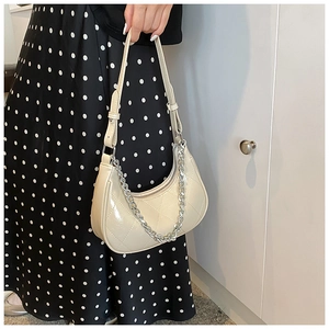 Détail du sac demi-lune en similicuir blanc cassé avec matelassage et chaîne argentée