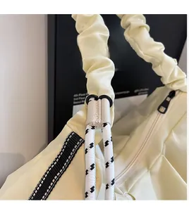 Dettaglio borsa a tracolla giallo crema di tendenza con tracolla a pieghe in nylon