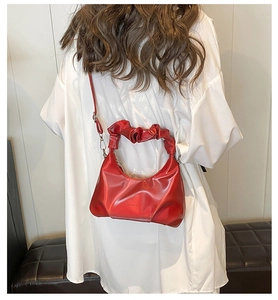 Polished red PU leather cloud bag detail with unique ruched handle on white shirt