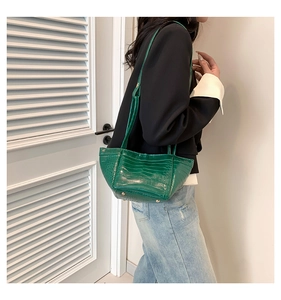 Detailed macro view of vibrant green PU handbag with premium crocodile texture and gold studs