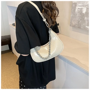 Détail du sac demi-lune en similicuir matelassé beige avec chaîne en métal argenté chic