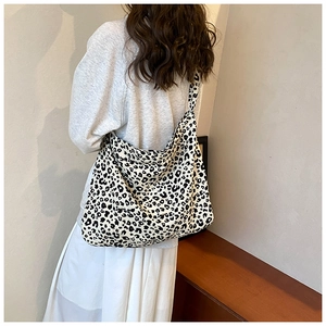 Rear view of a model wearing a leopard print canvas tote bag over the shoulder