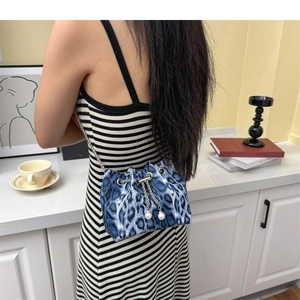 Detail of blue leopard print bucket bag with silver chain and white pearl drawstring