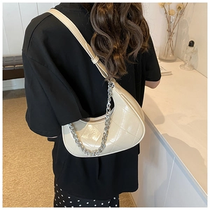 Détail du sac hobo matelassé beige avec chaîne argentée et design demi-lune