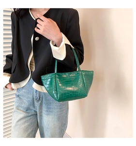 Deep green crocodile pattern PU leather handbag styled with a blazer and denim