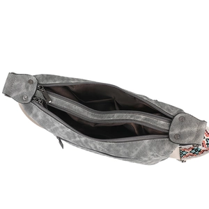 Detail of grey crossbody bag showing multiple inner compartments and embroidered strap
