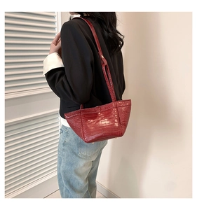 Detail shot of the red crocodile embossed PU leather handbag with gold metal feet