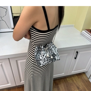 Detail of leopard print bucket bag featuring pearl drawstring and silver chain strap