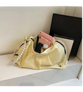 Dettaglio borsa hobo in nylon beige con tracolla intrecciata e spazio per tablet